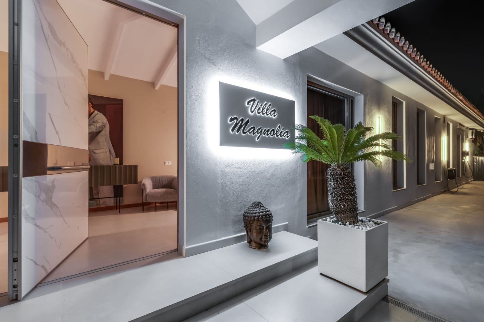 Illuminated Villa Magnolia entrance sign at night